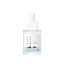 Load image into Gallery viewer, ROUND LAB 1025 Dokdo Ampoule is a deeply hydrating serum that combines the nourishing properties of Sea Water, Hydrolyzed Hyaluronic Acid, and Hydrolyzed Collagen to deliver intense moisture and improve skin elasticity. Enriched with Panthenol and Betaine, it soothes and calms the skin while Ceramide NP strengthens the skin barrier. Ideal for achieving a hydrated, plump, and radiant complexion, this ampoule is perfect for all skin types, especially those needing extra hydration and care.